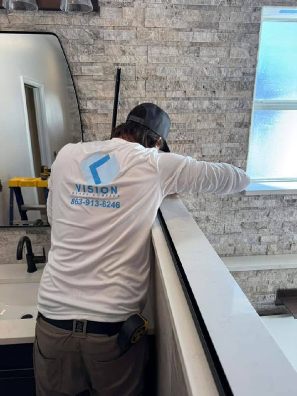 Vision Glass crew with branded shirts installing glass railings
