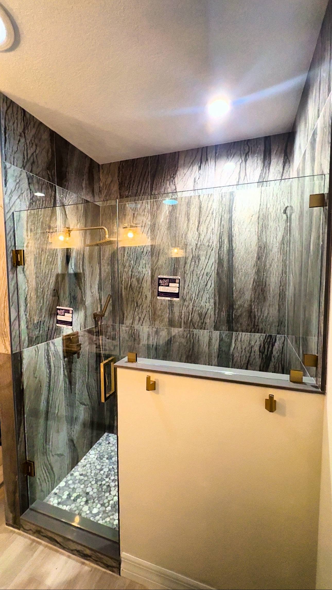Frameless shower with brushed gold hardware